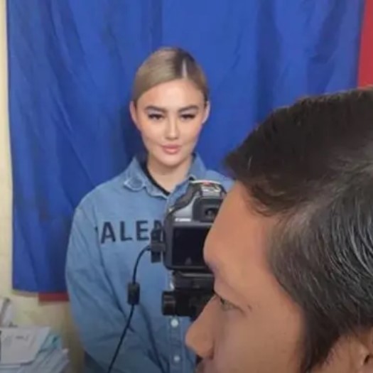 Dalam video yang beredar, Agnez Mo terlihat mengenakan kemeja berwarna biru dengan tulisan brand Balenciaga saat foto pembuatan e-KTP.